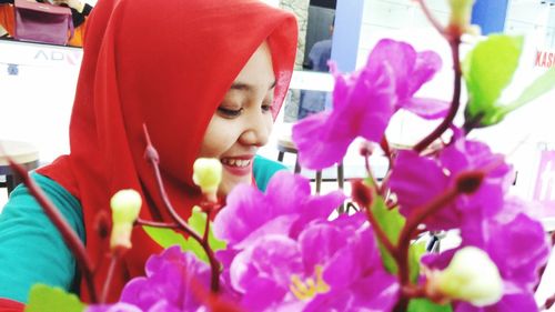 Close-up of young woman with pink flowers