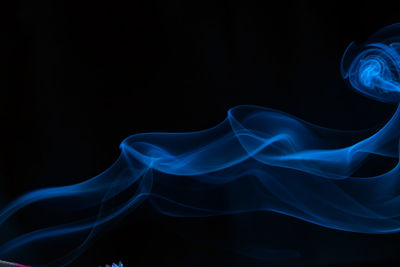 Close-up of blue smoke against black background