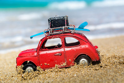 Close-up of toy car on beach against sky