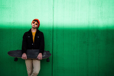 Portrait of man sitting against wall