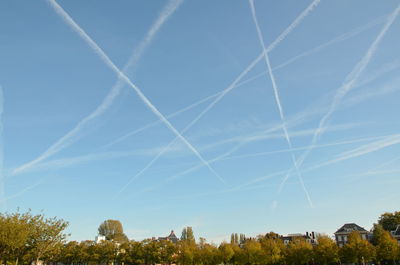 Vapor trails against blue sky