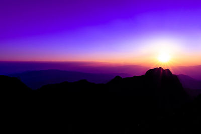 Scenic view of silhouette mountains against sky at sunset