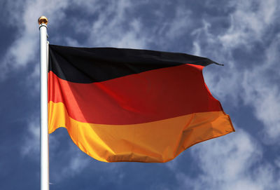 Low angle view of german flag against cloudy sky