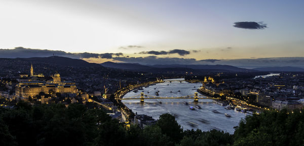 Illuminated chain bridge over river danube against sky at dusk