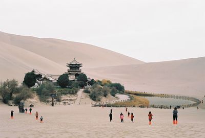 People on beach against clear sky