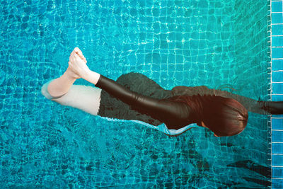 Low section of woman swimming in pool