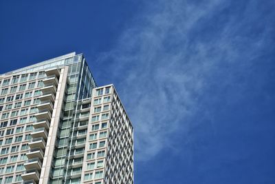 Low angle view of modern building against blue sky