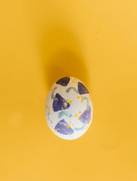 Directly above shot of easter egg on yellow background