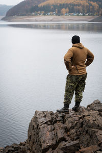 Rear view of man standing on rock