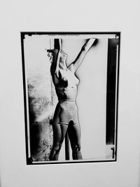 Reflection of woman in mirror standing on wall