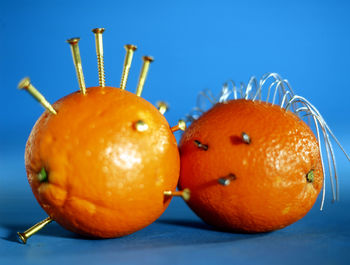 Close-up of screws on oranges against blue background