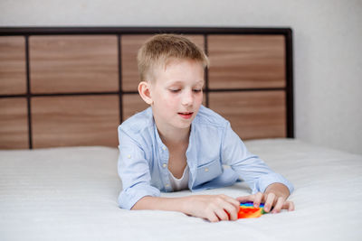 Portrait of boy playing on bed at home