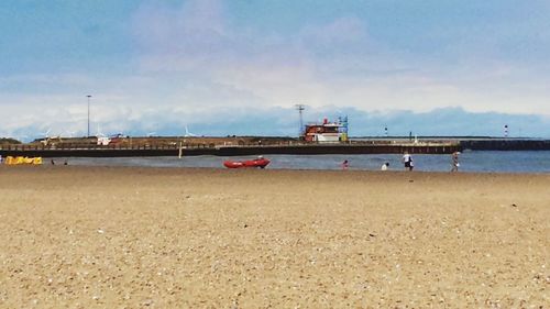 Ship moored on beach against sky