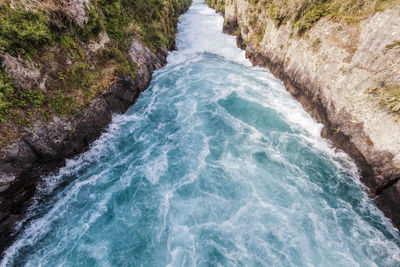 Scenic view of river flowing amidst rocks