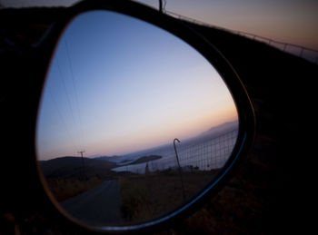 Close-up of side-view mirror against clear sky