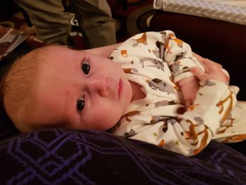 Portrait of cute baby lying on bed