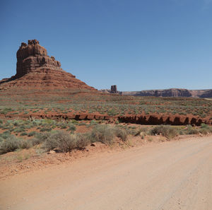 Rock formations on landscape against clear blue sky