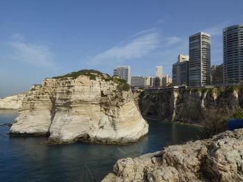 Rock formations by sea against sky