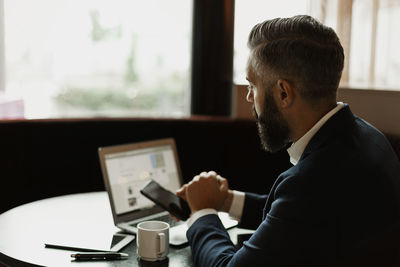 Businessman in cafe using cell phone