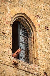 Tourist taking photo from window medieval castle of serralunga d'alba, langhe wine district, italy,