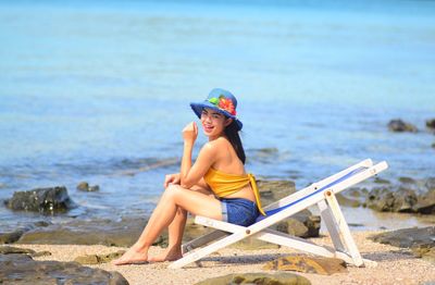 Side view of boy sitting on beach