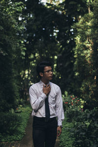 Young man looking away in forest