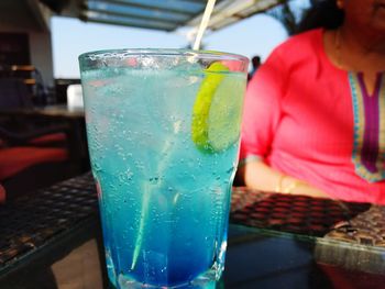 Close-up of hand holding drink on table