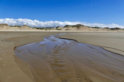 Scenic view of desert against blue sky