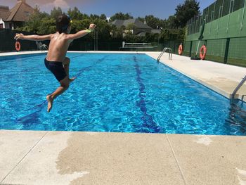 Woman jumping in swimming pool