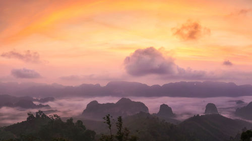 Scenic view of silhouette mountains against orange sky