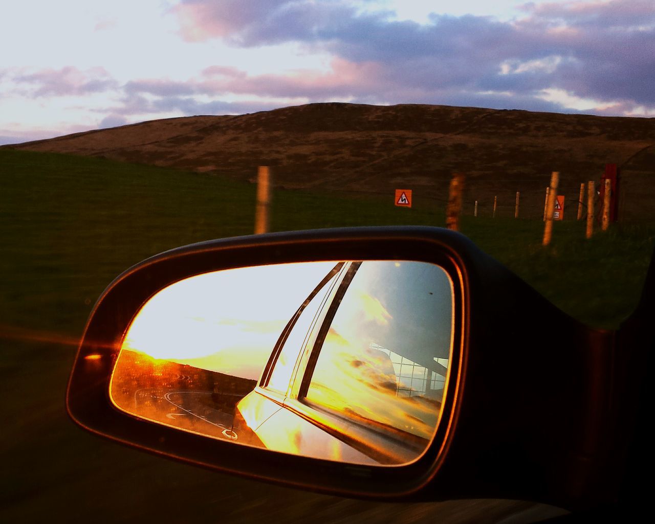 transportation, mode of transport, land vehicle, car, side-view mirror, sky, sunset, reflection, glass - material, cloud - sky, vehicle interior, part of, landscape, transparent, travel, cloud, close-up, cropped, window, car interior