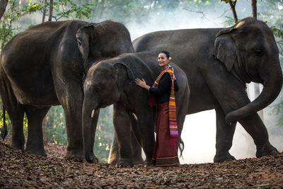 Young woman standing with elephant in temple