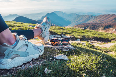 Woman's legs lying on top of the mountain. rest after reaching the top of the mountain. 