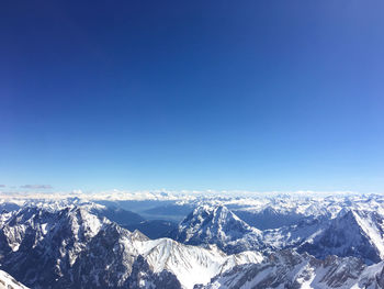 Scenic view of snowcapped mountains against clear blue sky