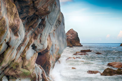 Scenic view of rocks in sea against sky