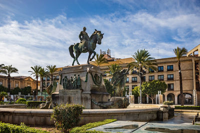 Statue of historic building against cloudy sky