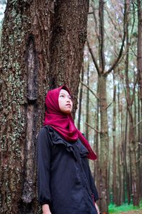 Portrait of young woman standing in forest