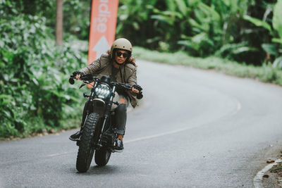 Portrait of man riding motorcycle on road