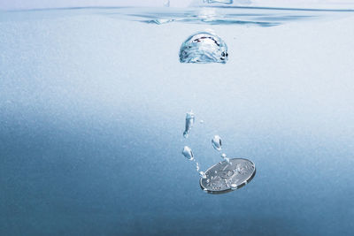 Close-up of bubbles over sea against blue background
