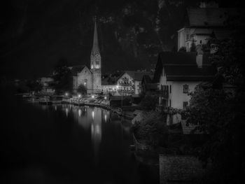 Illuminated buildings by lake at night