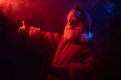 Side view of man in red fire against black background