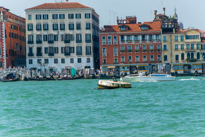 Boats in sea against buildings in city