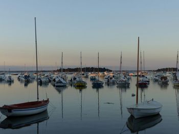 Boats moored in sea at sunset