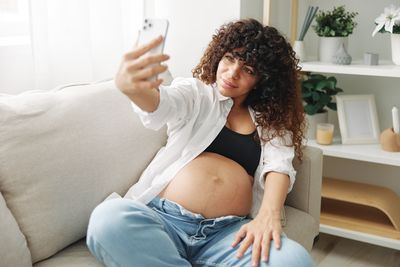 Young woman sitting on sofa at home