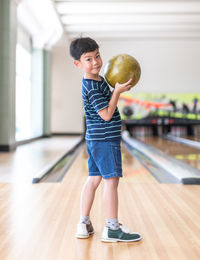 Portrait of cute boy holding bowling ball