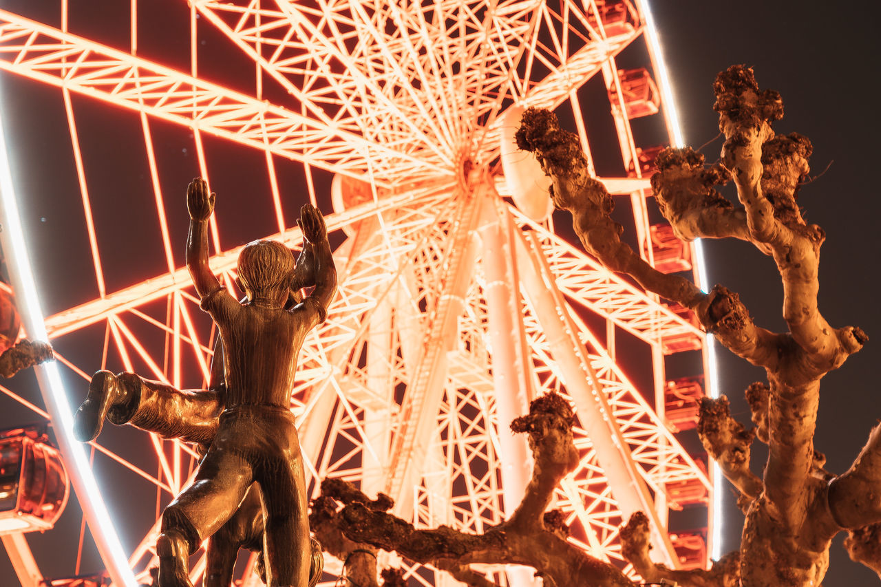 LOW ANGLE VIEW OF ILLUMINATED SCULPTURE AT NIGHT DURING FESTIVAL