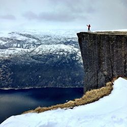 Person standing by lake during winter