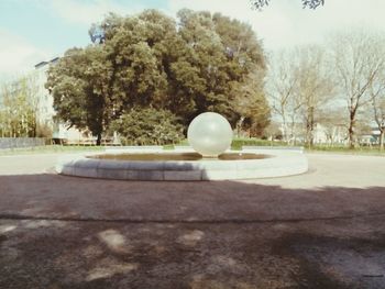 Digital composite image of ball and tree on field in park