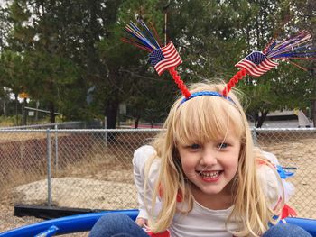 Portrait of smiling girl with american flag head band playing in park
