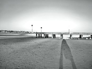 People on beach against clear sky